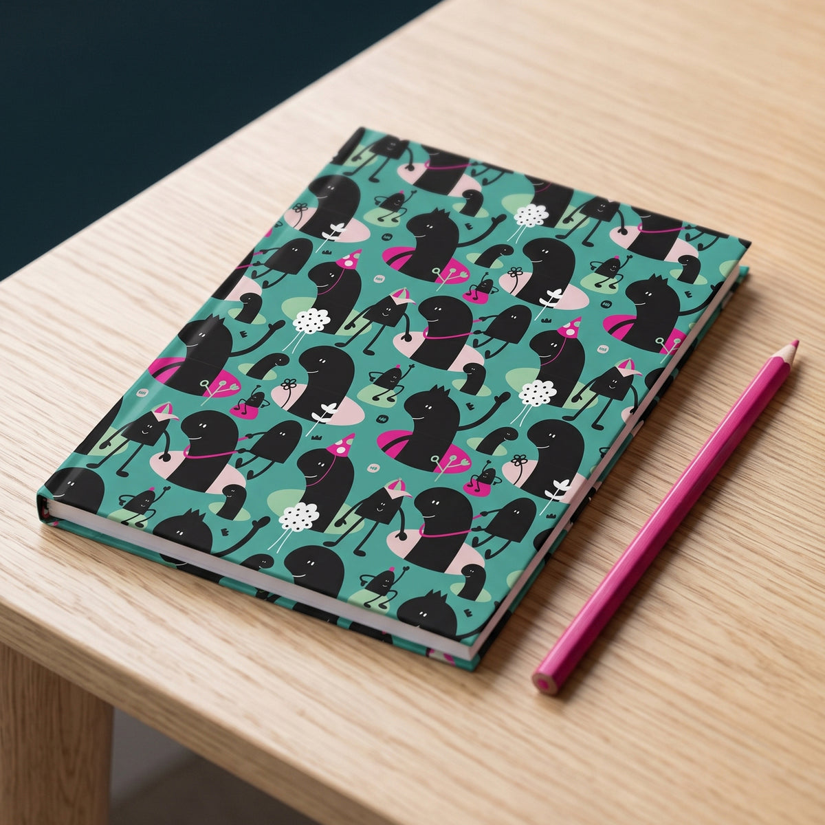 Carnet rigide Lolilé avec motif répétitif de petits personnages malicieux et festifs sur fond bleu-vert, avec touches de rose.